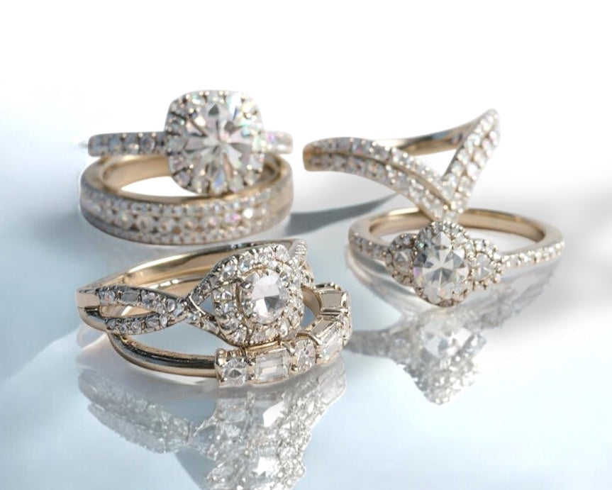 Set of gold and diamond rings on a reflective surface