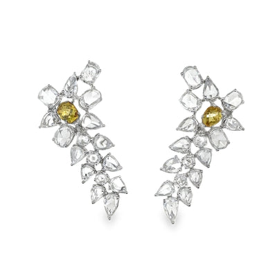 Pair of earrings with clear and yellow gemstones on a white background