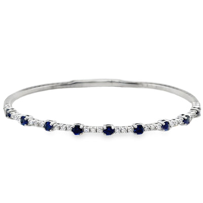 Silver bracelet with blue and clear stones on a white background
